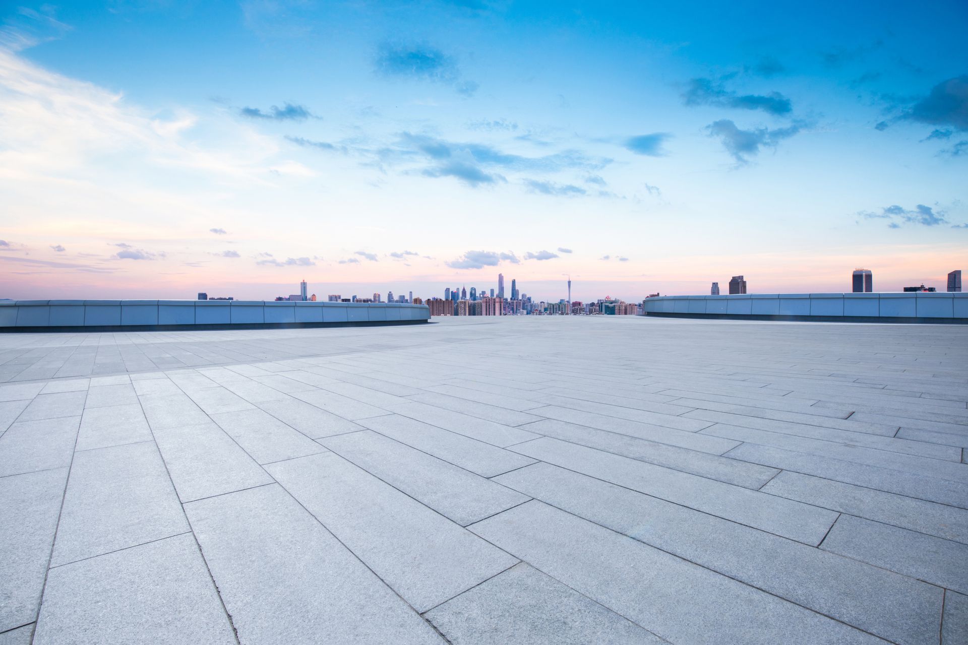 View from a roof of a neighborhood with snow-like deposits on asphalt shingles.