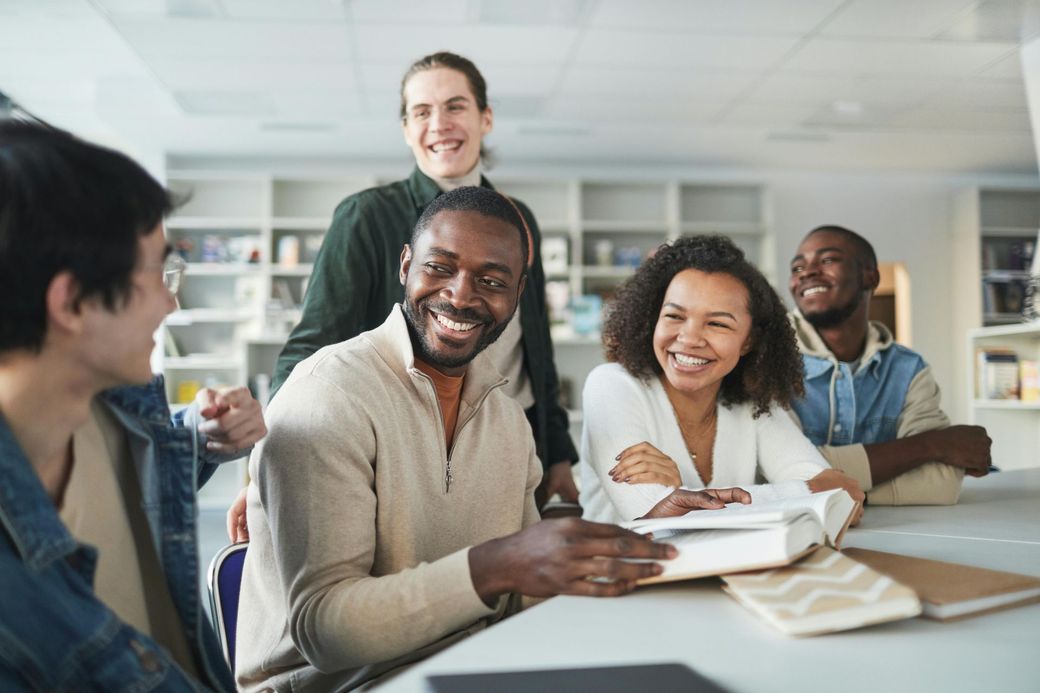 A group of people are sitting around a table in a library.