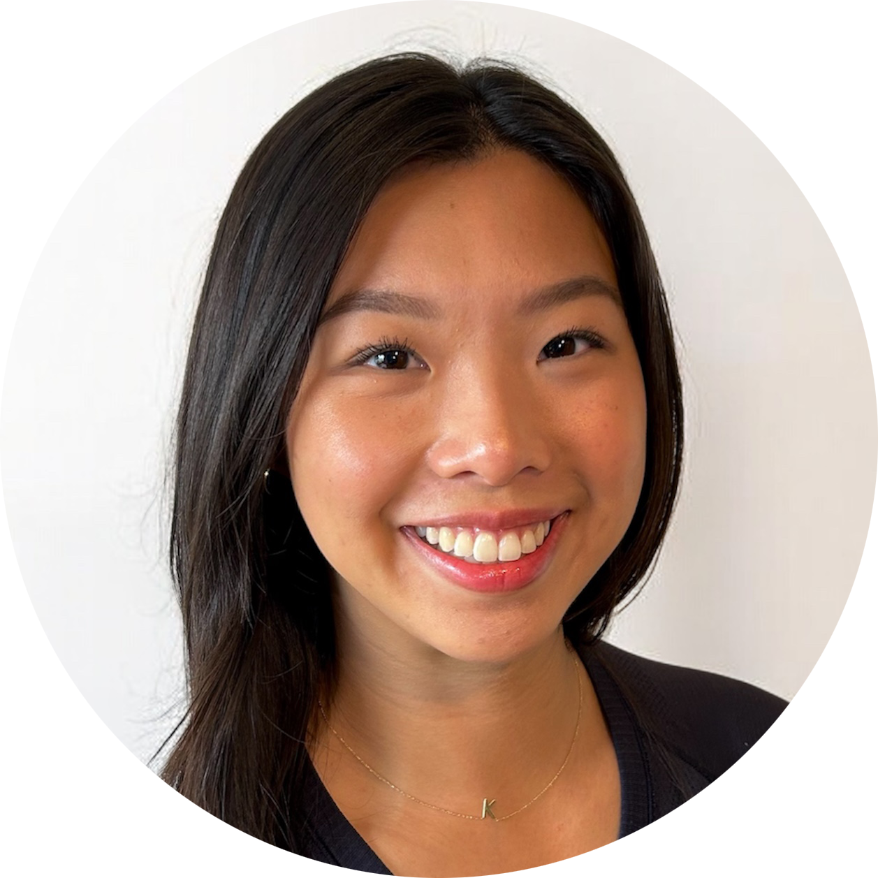 A woman wearing a necklace and earrings is smiling in a circle.