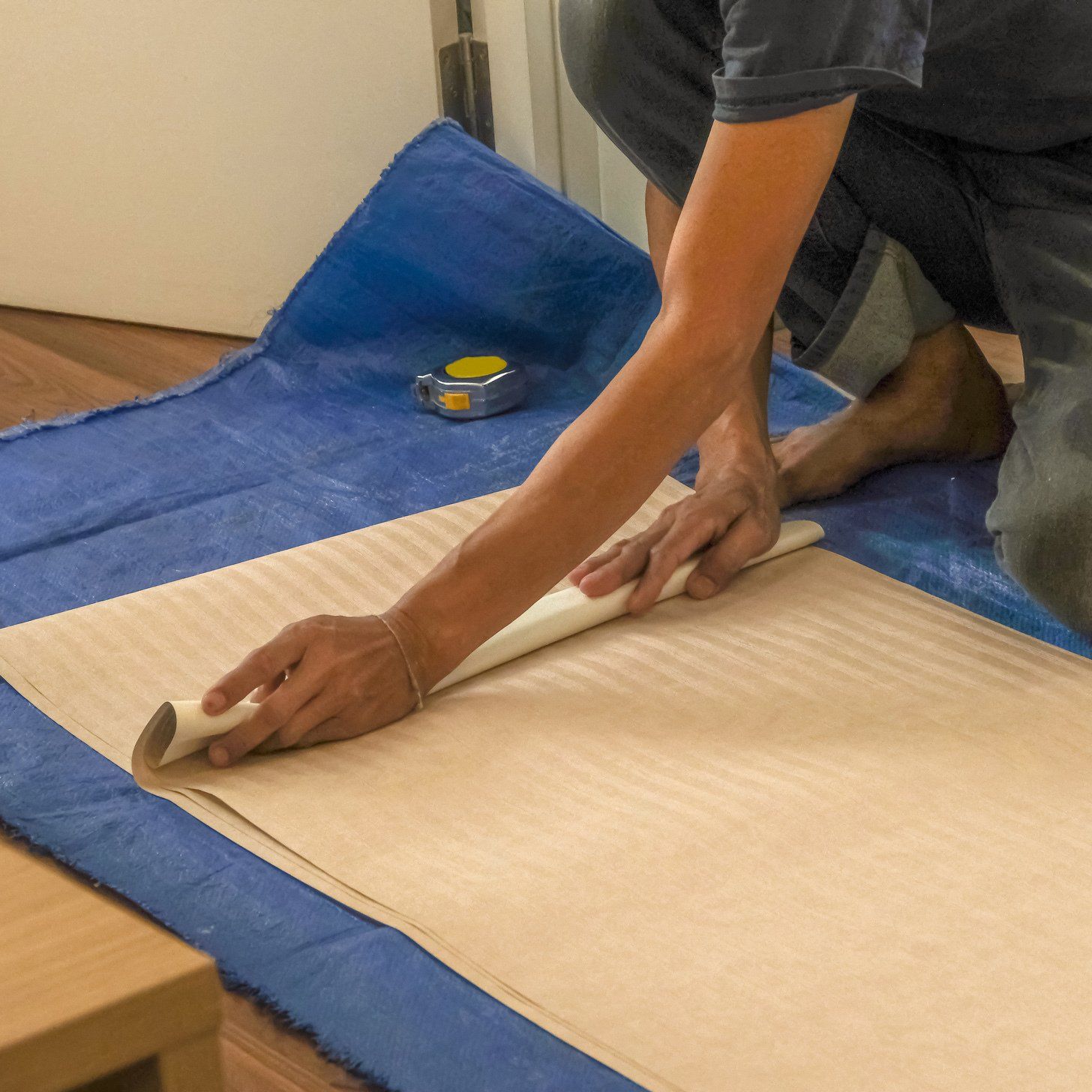Man Preparing Wallpaper Installation — Sheboygan, WI — Hohmann Painting & Decorating, Inc. Man Preparing Wallpaper Installation — Sheboygan, WI — Hohmann Painting & Decorating, Inc.