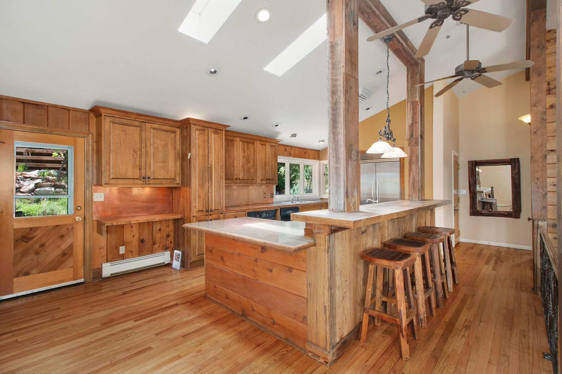 Wooden kitchen with a breakfast bar and skylights.