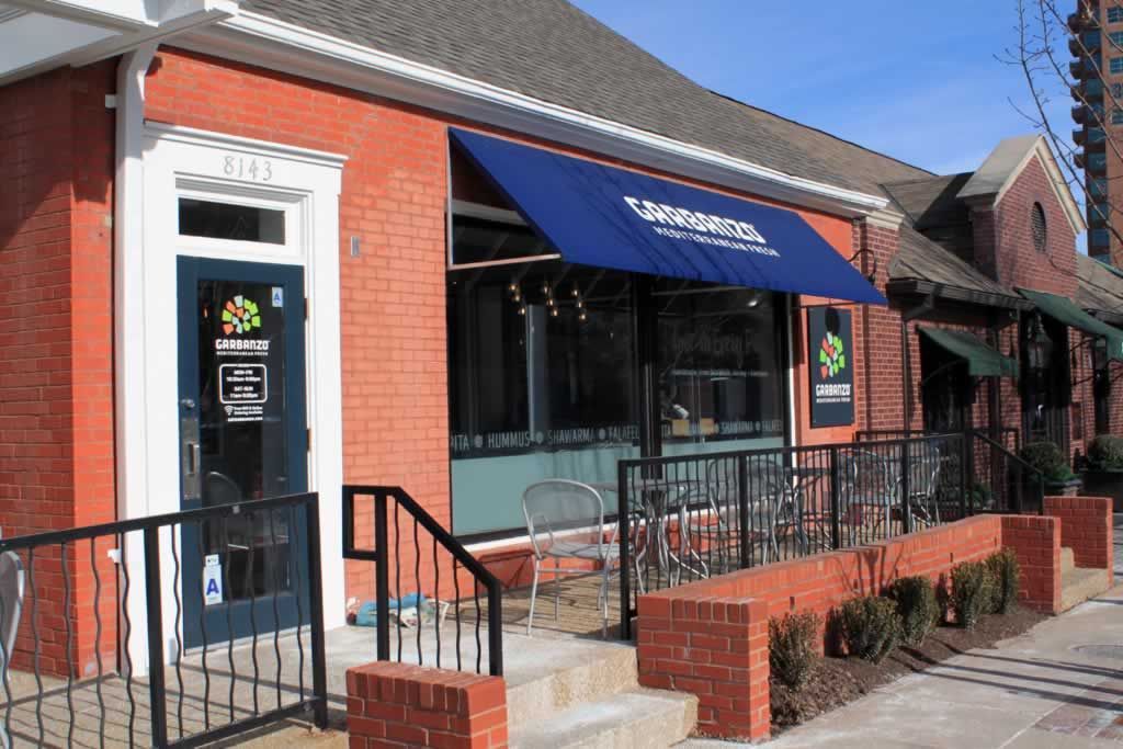 A brick building with a blue awning that says taco bell