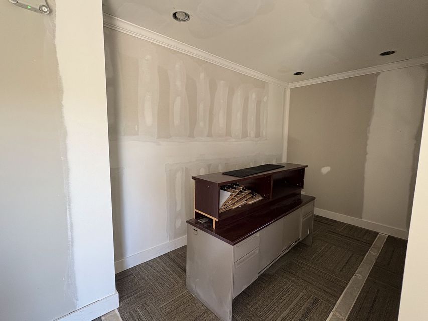Small unfinished room with beige walls and a wooden cabinet centered on the floor.