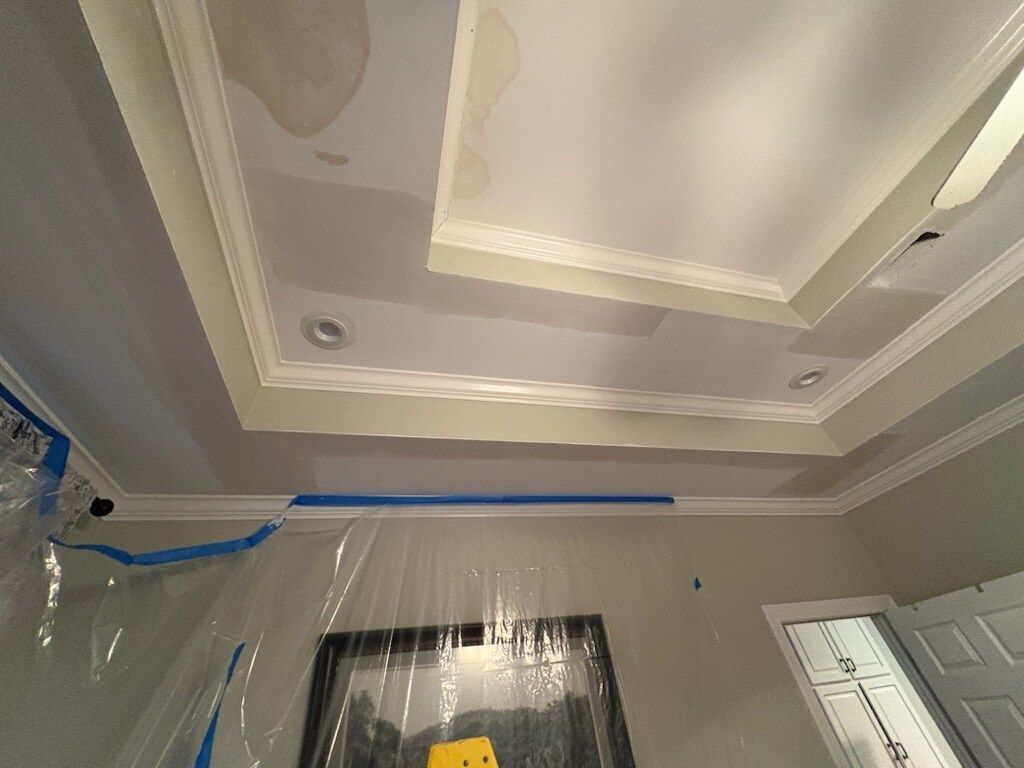Ceiling under renovation, covered in plastic sheeting and blue painter’s tape.