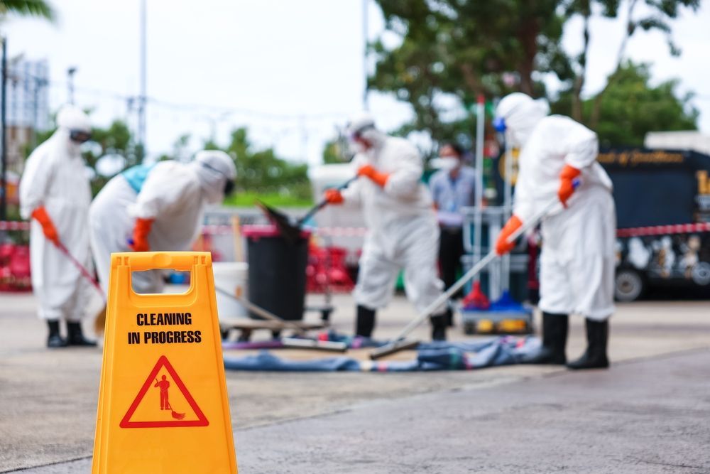 Person in protective suit sanitizing an office with a sprayer.