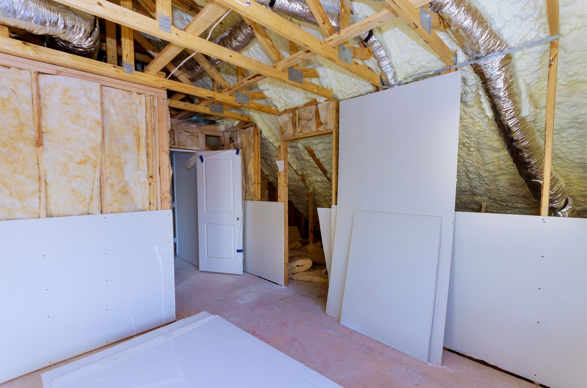 A room in a house under construction with a lot of drywall.