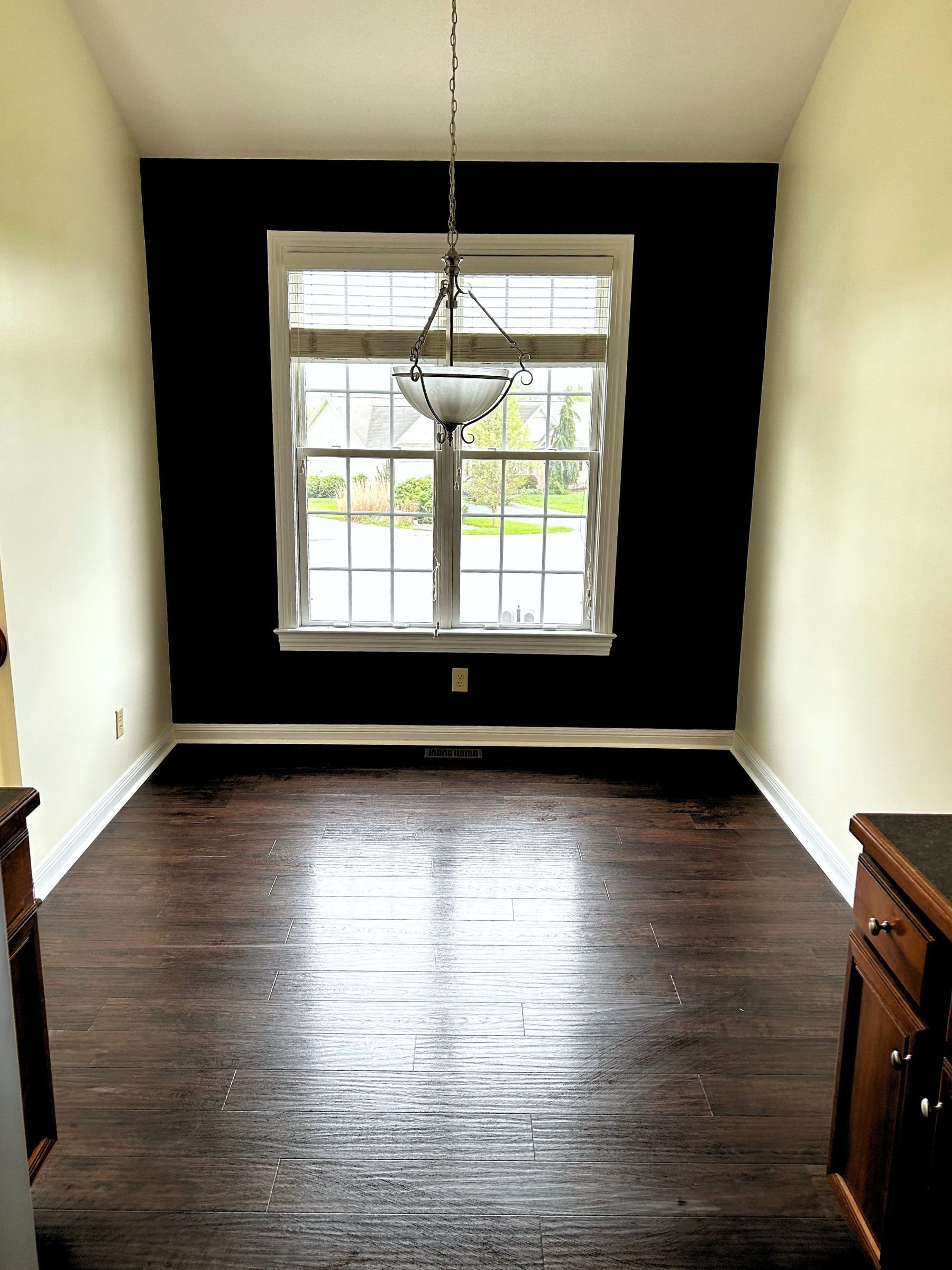 A room with a wooden floor and a door that is open.