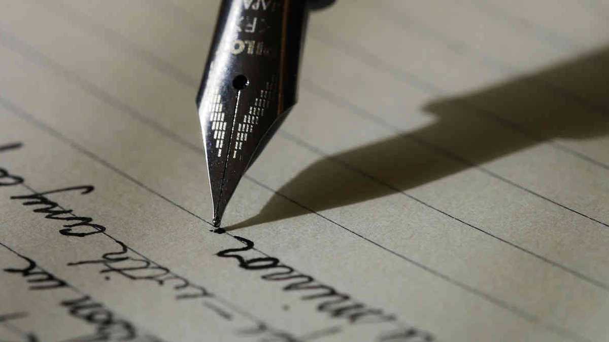 Un primer plano de una pluma estilográfica escribiendo en un trozo de papel.