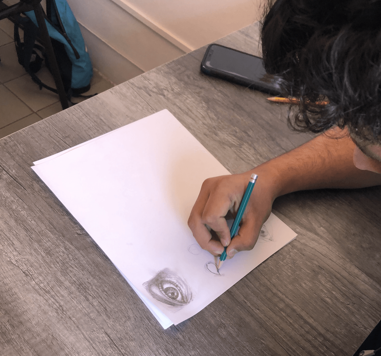 Una persona está dibujando en un trozo de papel con un lápiz.