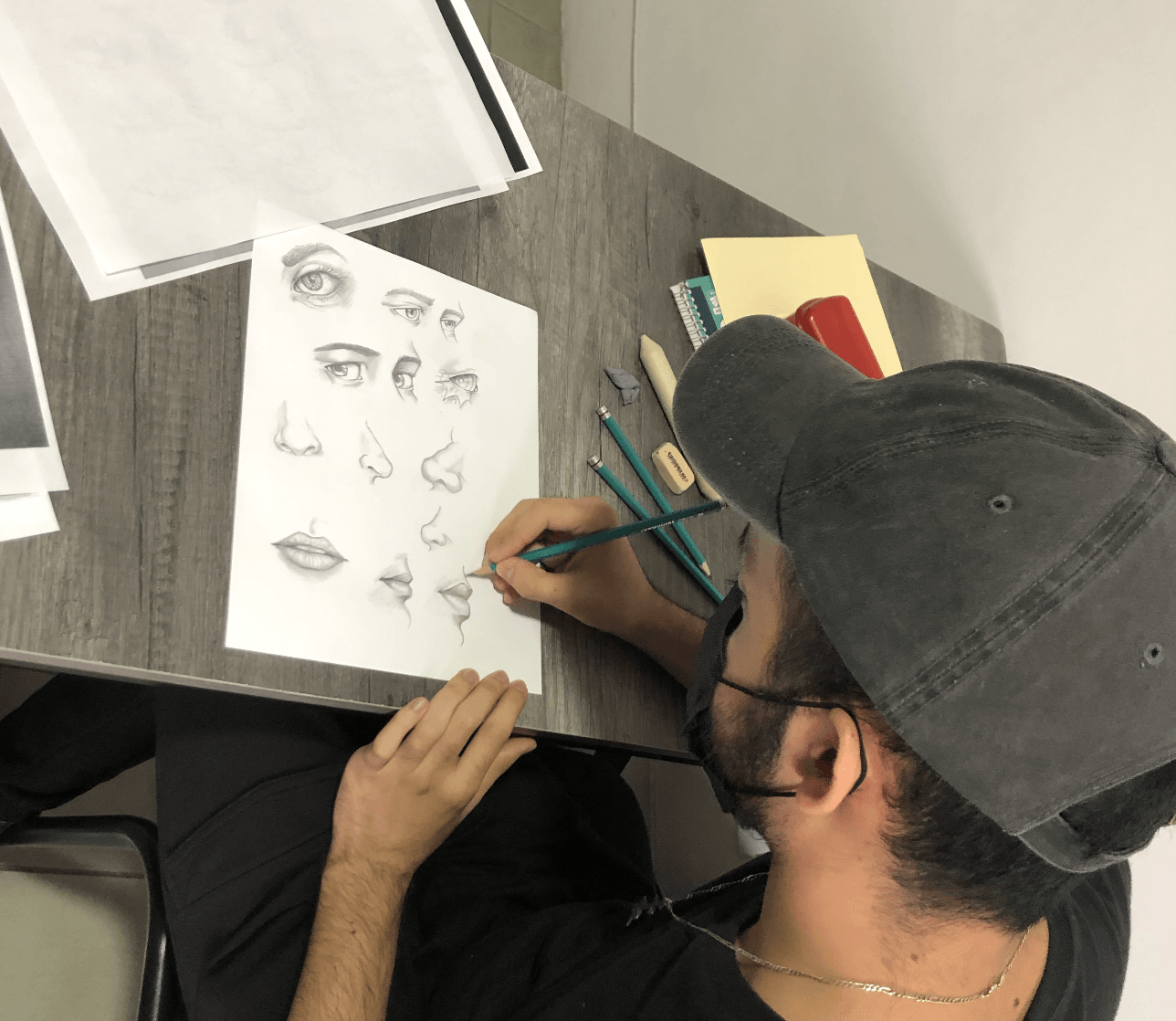 Un hombre que lleva un sombrero está dibujando en un trozo de papel.