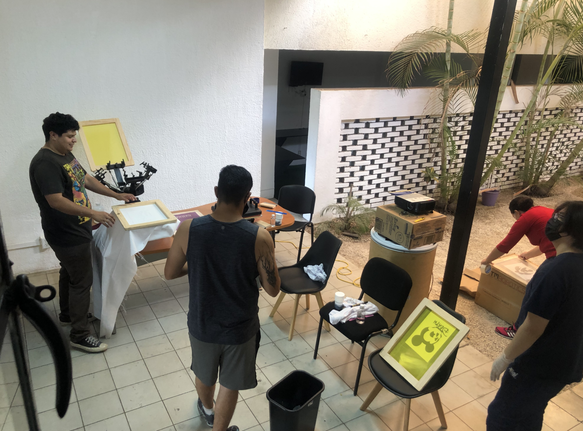Un grupo de personas están de pie alrededor de una mesa en una habitación.