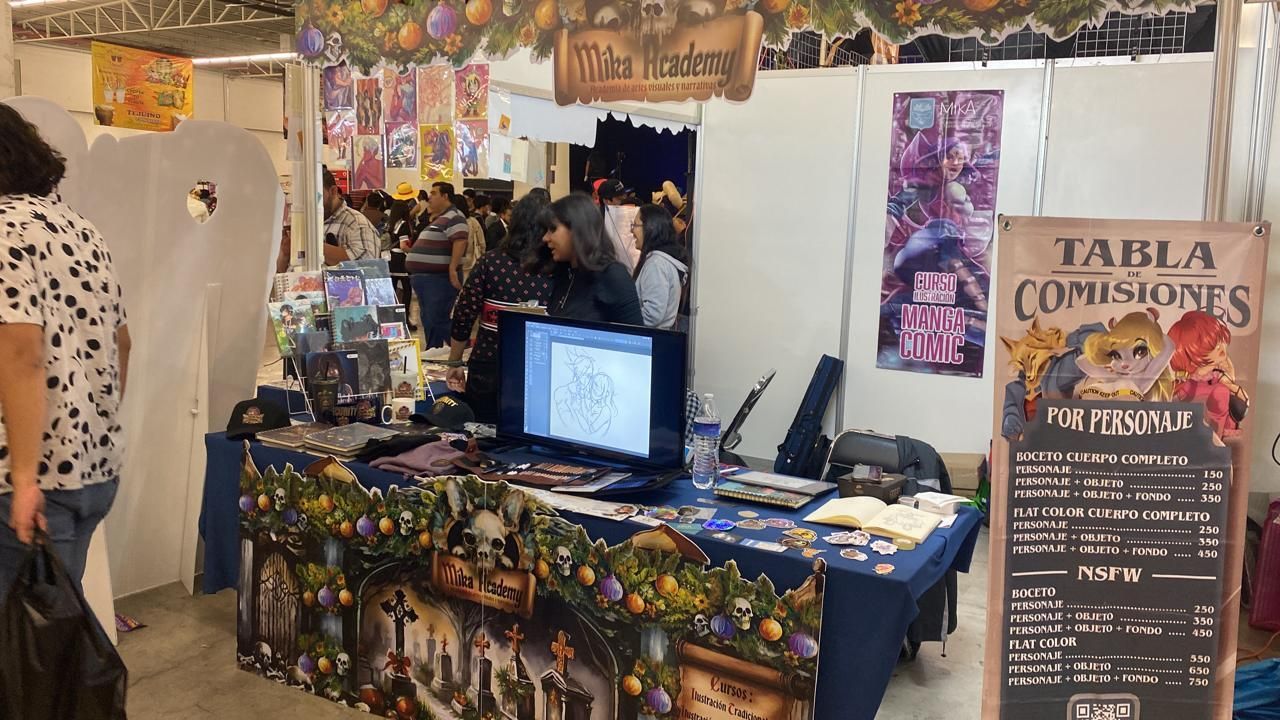 Una mujer está parada frente a una mesa con una computadora encima.