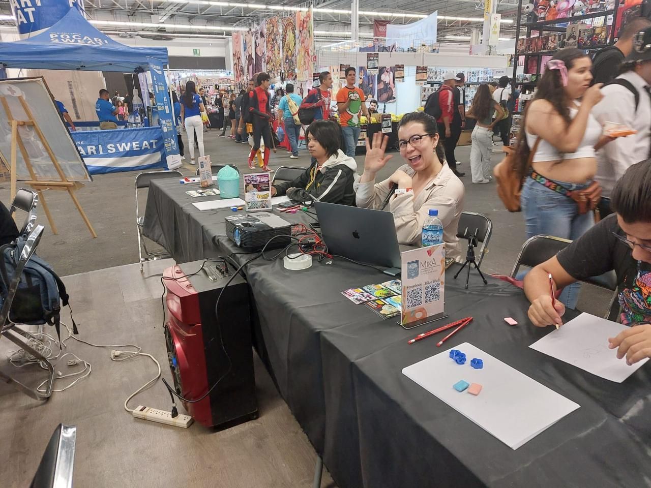 Un grupo de personas está sentado en una mesa con computadoras portátiles.