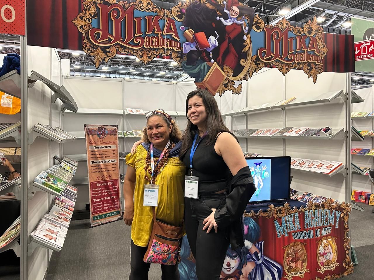 Dos mujeres posan para una fotografía en una convención.