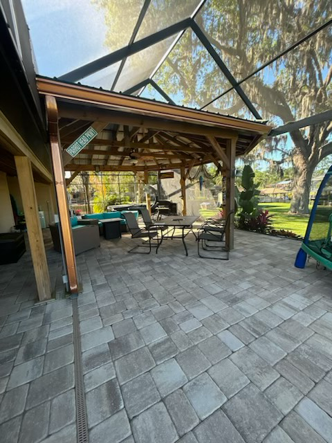 a patio with a screened in porch and a table and chairs underneath it