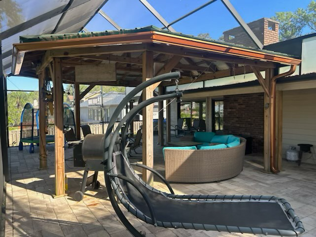 a patio with a swing and a couch under a gazebo