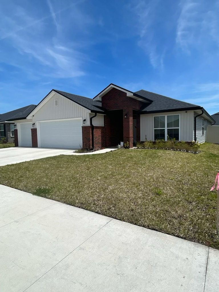 a house with a brick roof and a white garage door is for sale