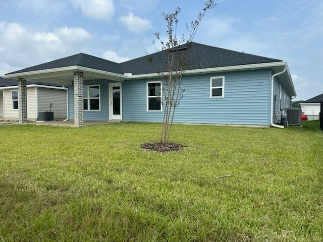 a blue house with a black roof is sitting on top of a lush green lawn