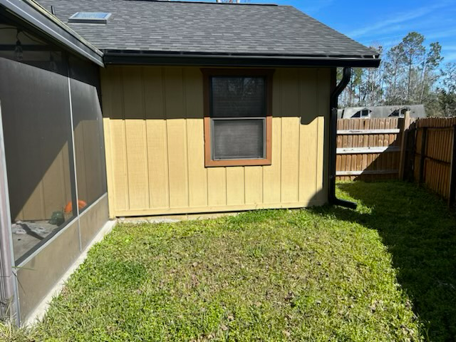 the backyard of a house with a screened in porch and a window.