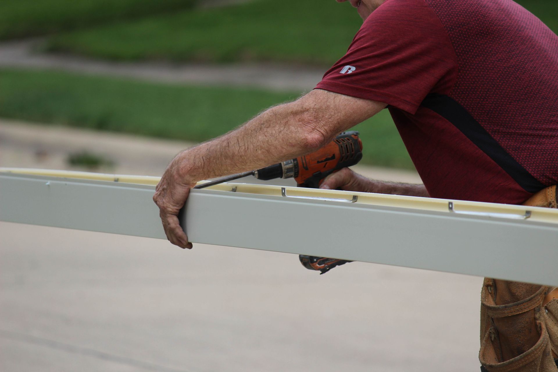 a man is using a drill to drill a hole in a gutter