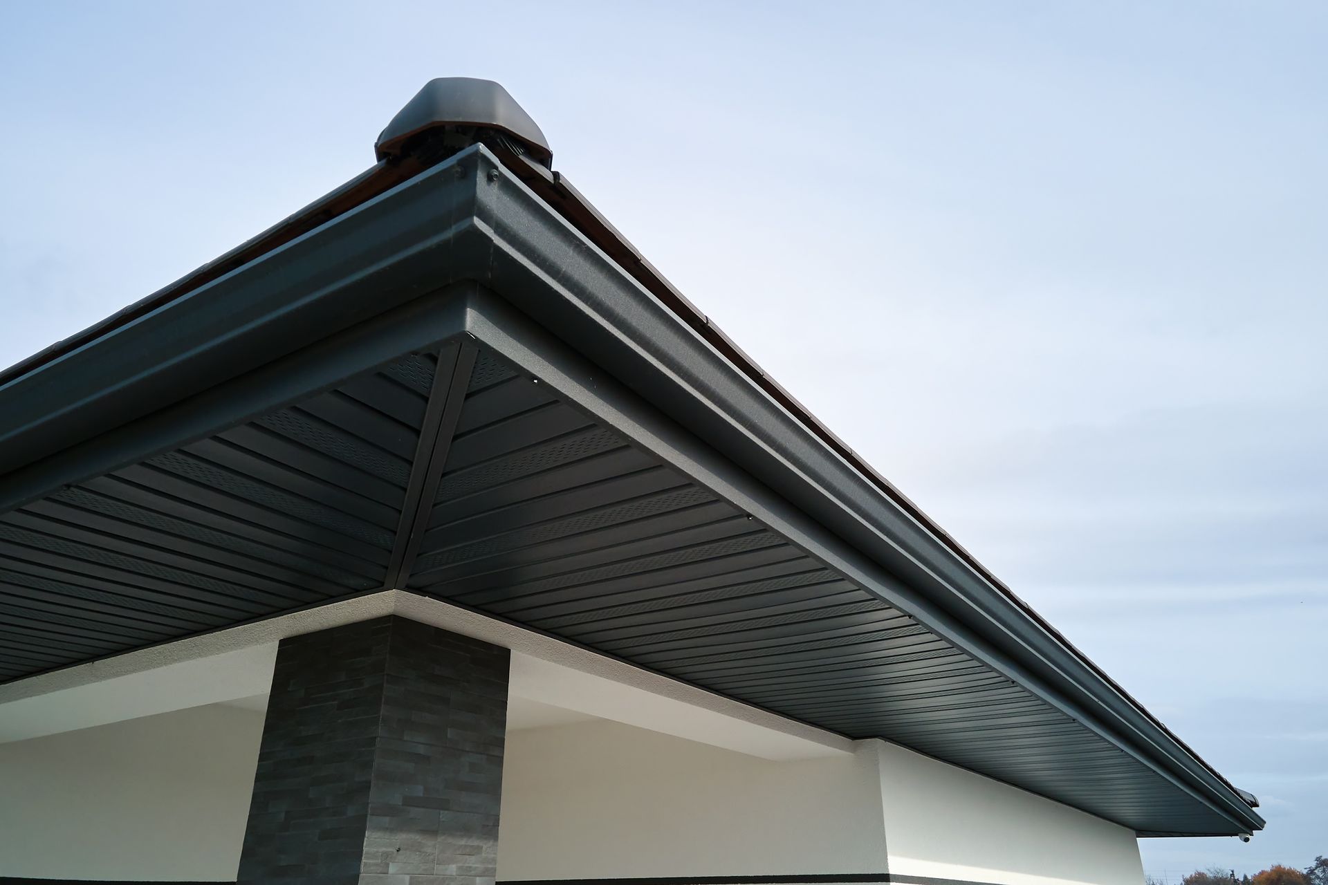 the roof of a house has a black gutter on it