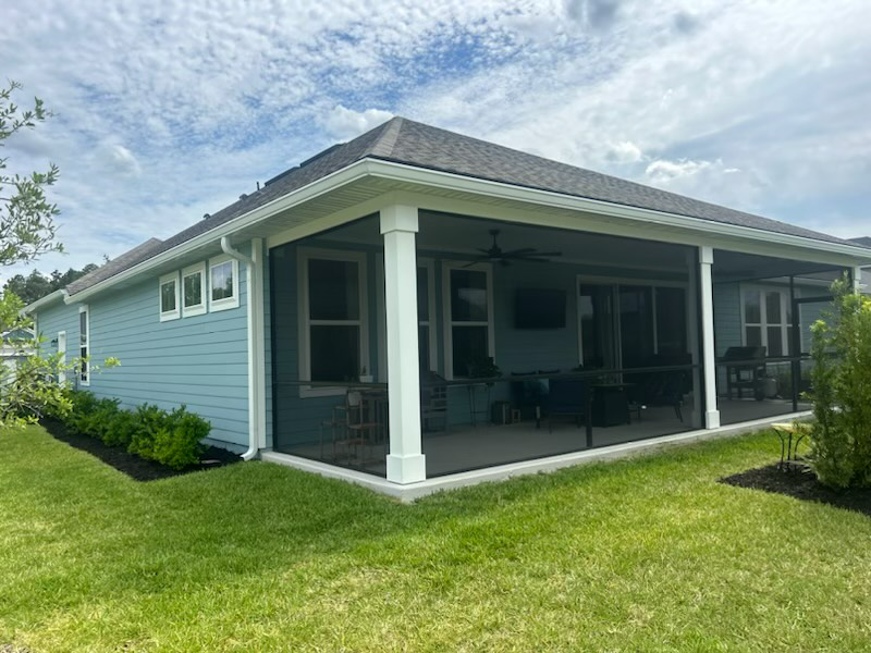 a blue house with a screened in porch in the backyard