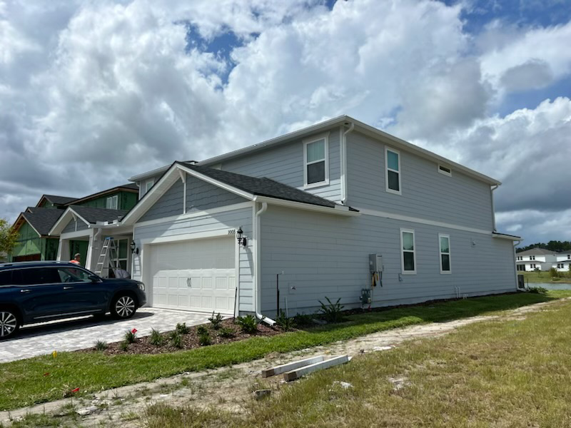 A house with a screened in porch and a basketball hoop in front of it.