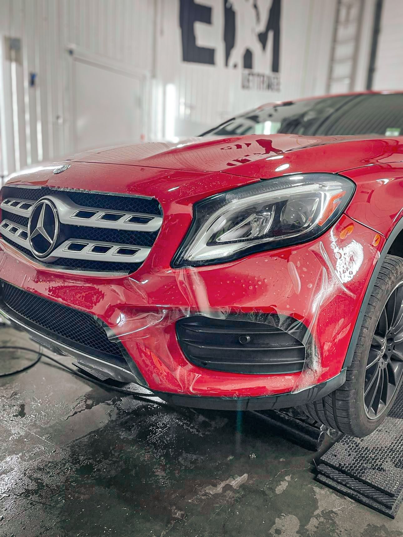 Une Mercedes Benz rouge est garée dans un garage.