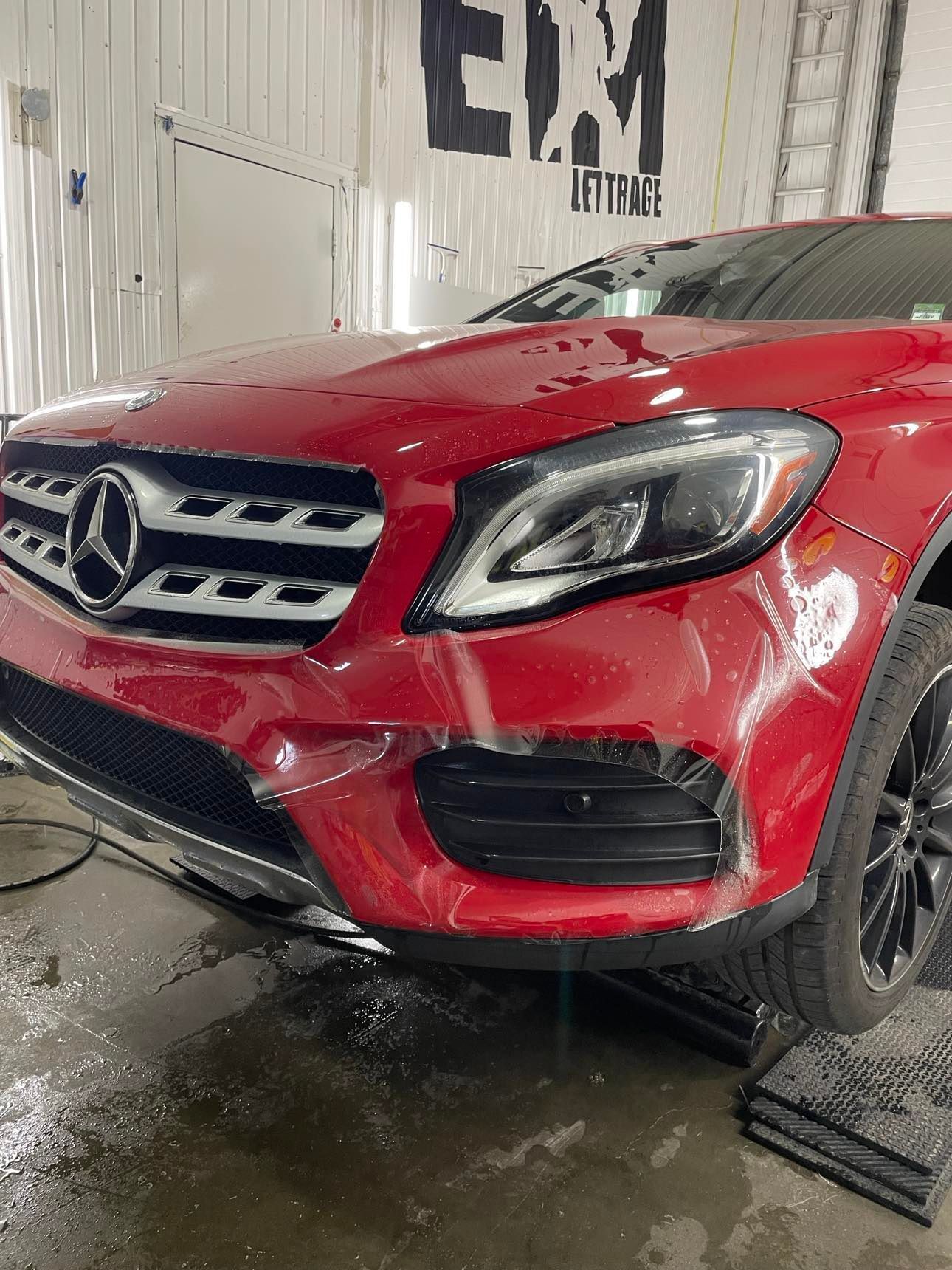 Une Mercedes Benz rouge est garée dans un garage.