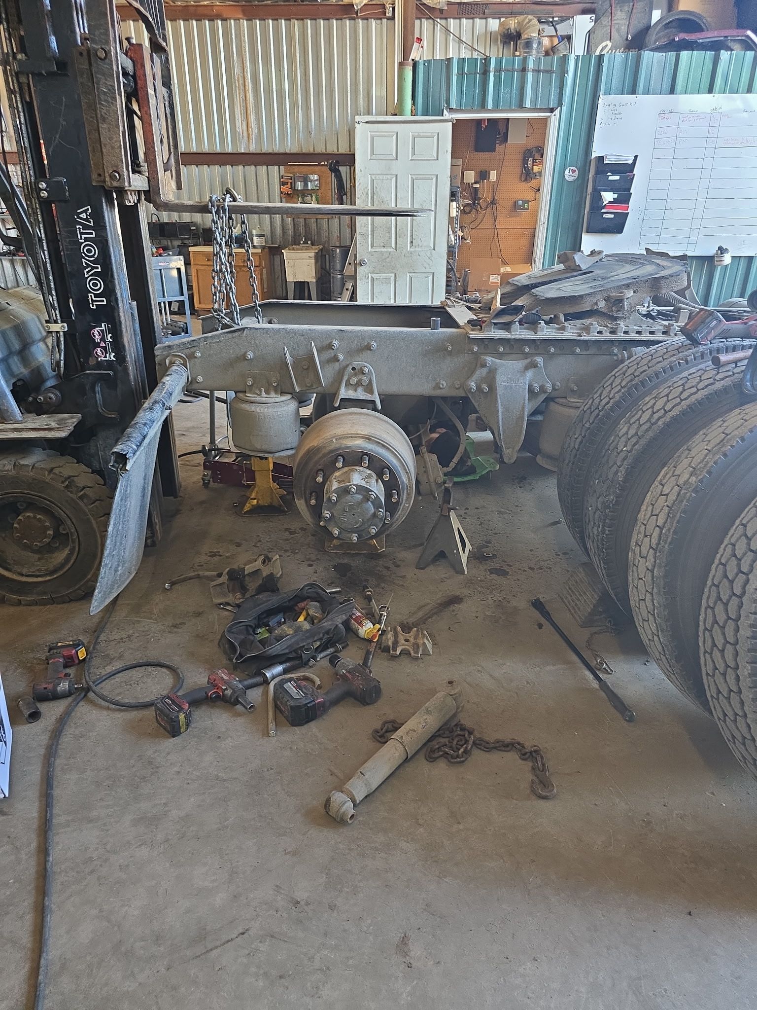 A truck is being dismantled in a garage.