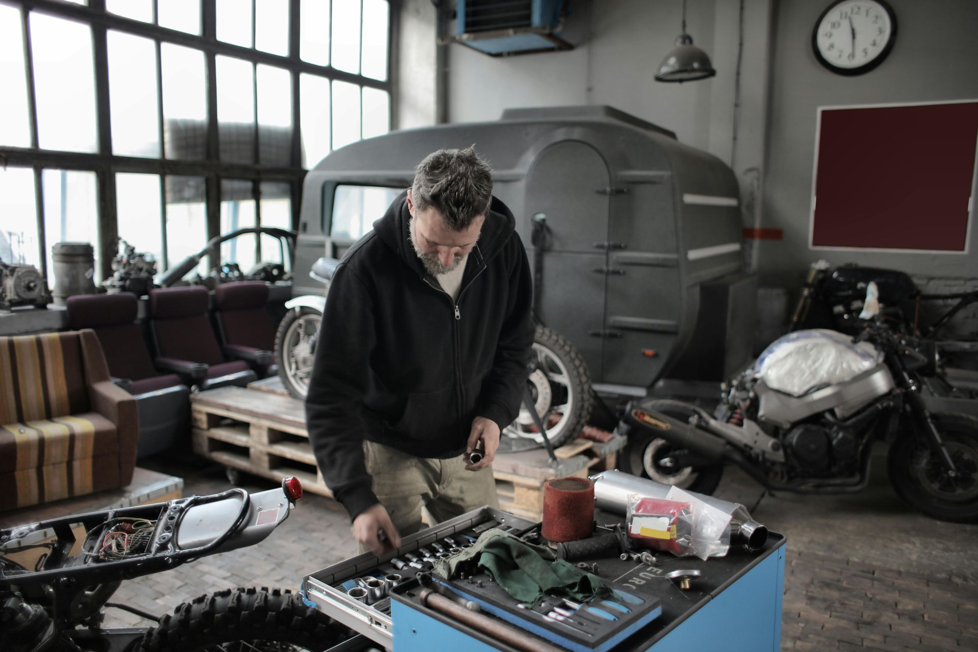 A man is working on a motorcycle in a garage.