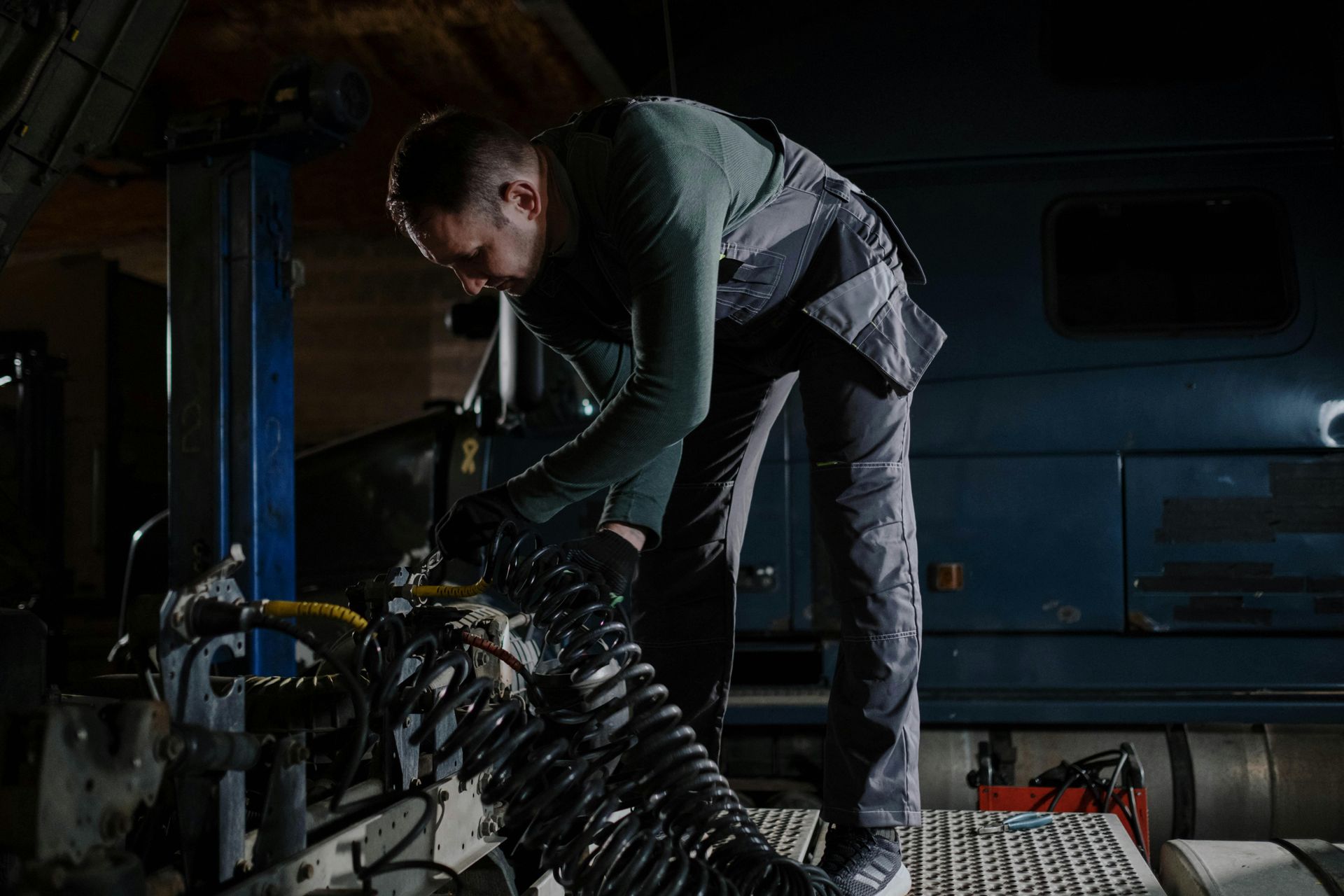 A man is working on a truck in a garage.