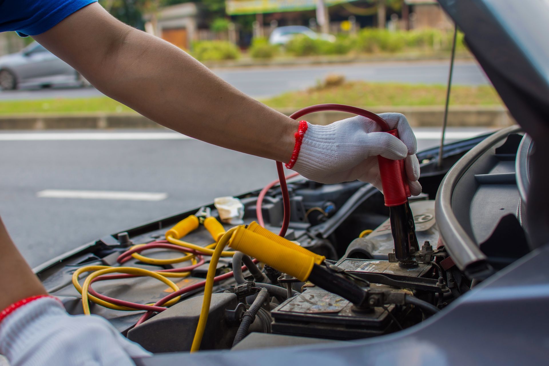 A person is charging a car battery with a jump starter.