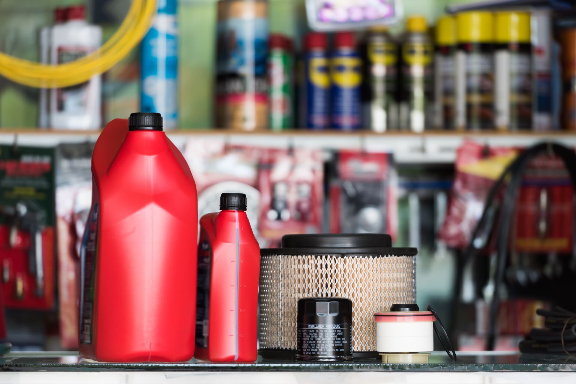 A shelf filled with lots of car parts and bottles of oil.
