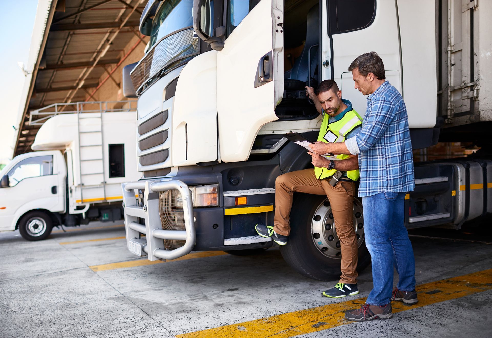 Two Men Are Standing Next to a Truck in a Parking Lot — Pearl, MS — Hall’s Towing Service
