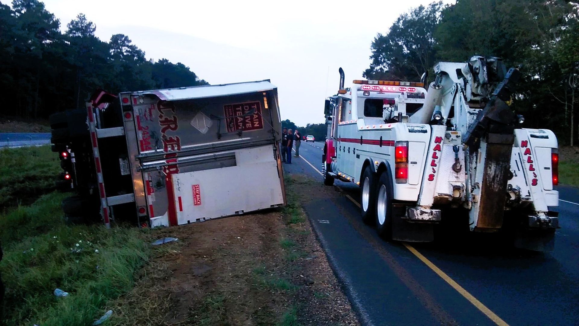 A Man Is Attaching a Trailer to the Back of a Truck — Pearl, MS — Hall’s Towing Service