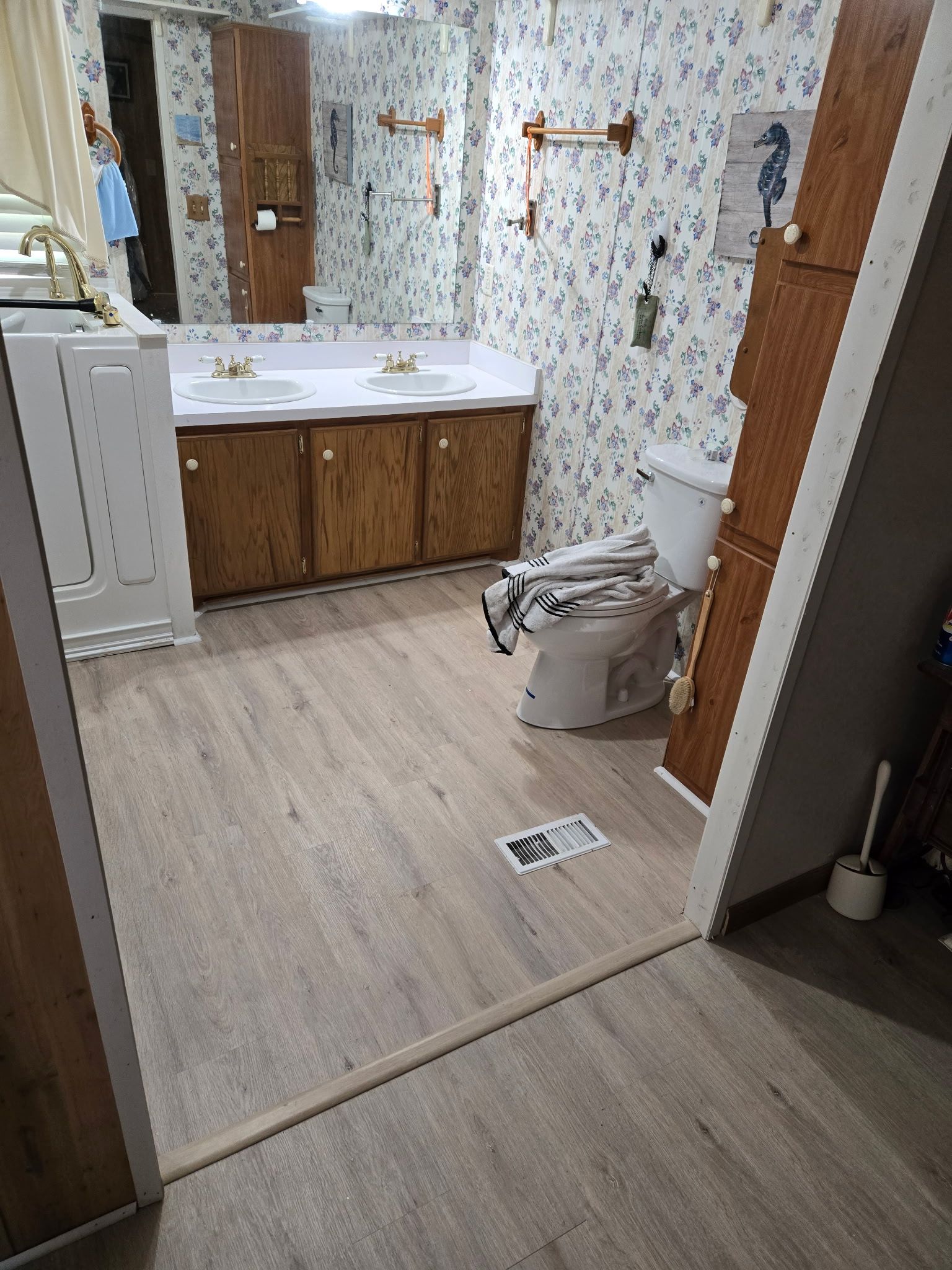 A bathroom with a toilet , sink and mirror.