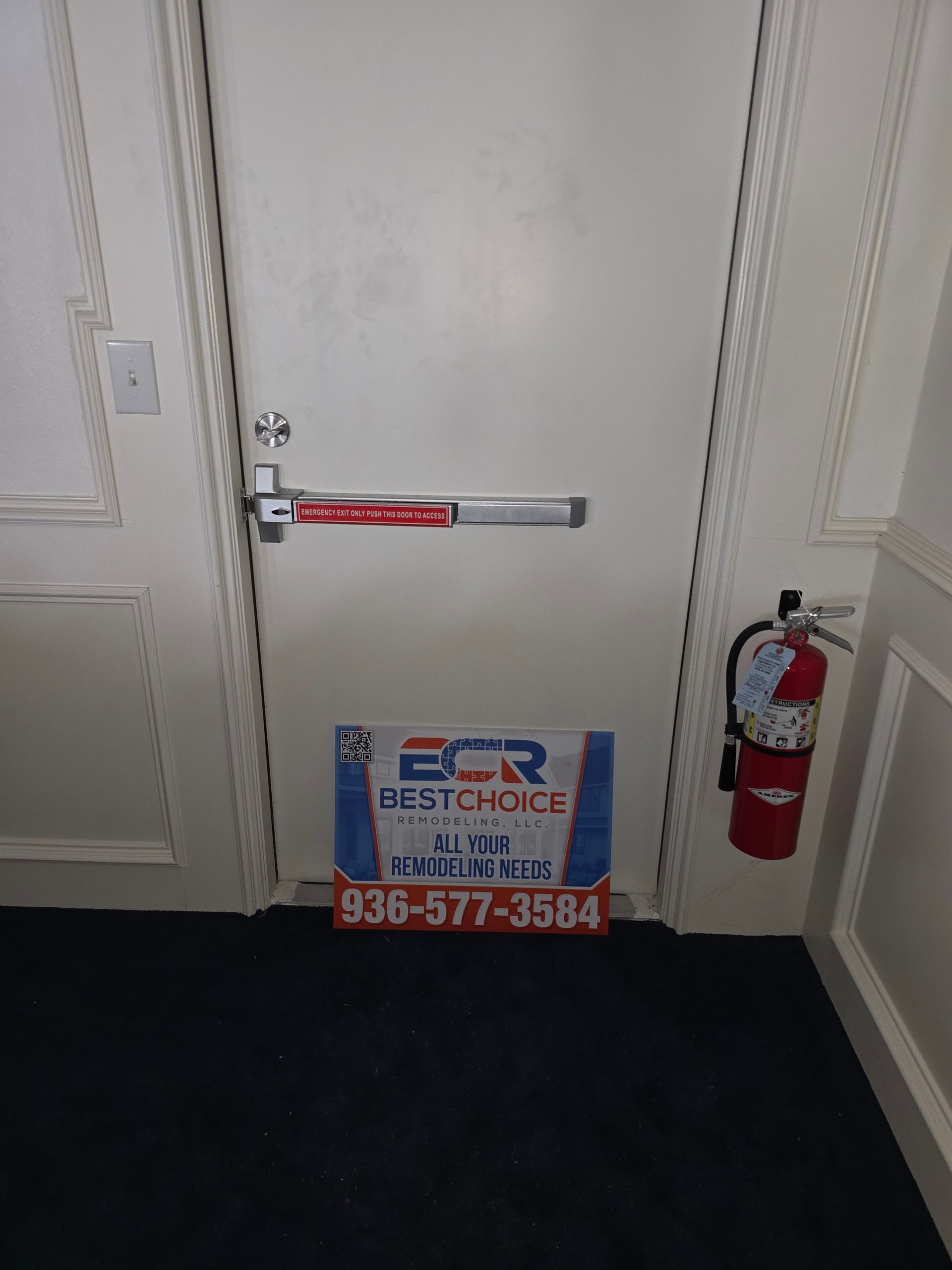 A door with a sign on it and a fire extinguisher on the wall.