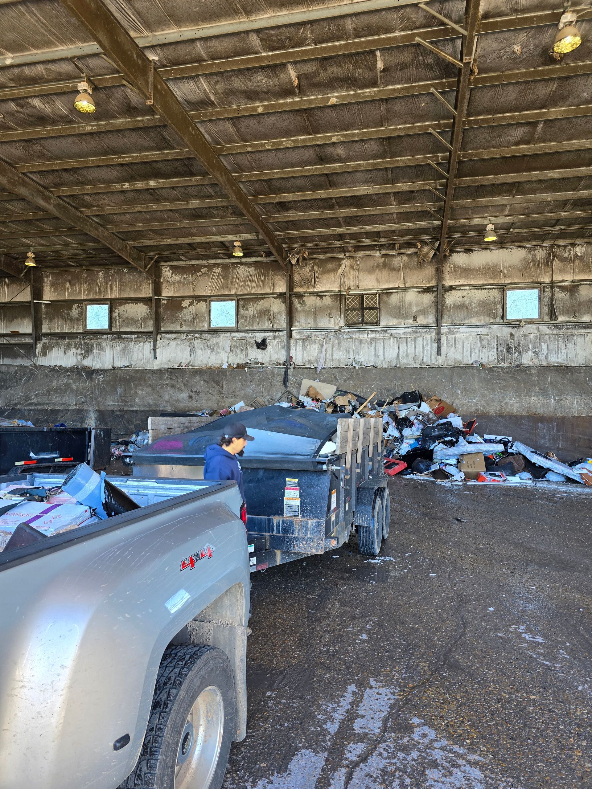 A truck is parked in a warehouse next to a trailer.
