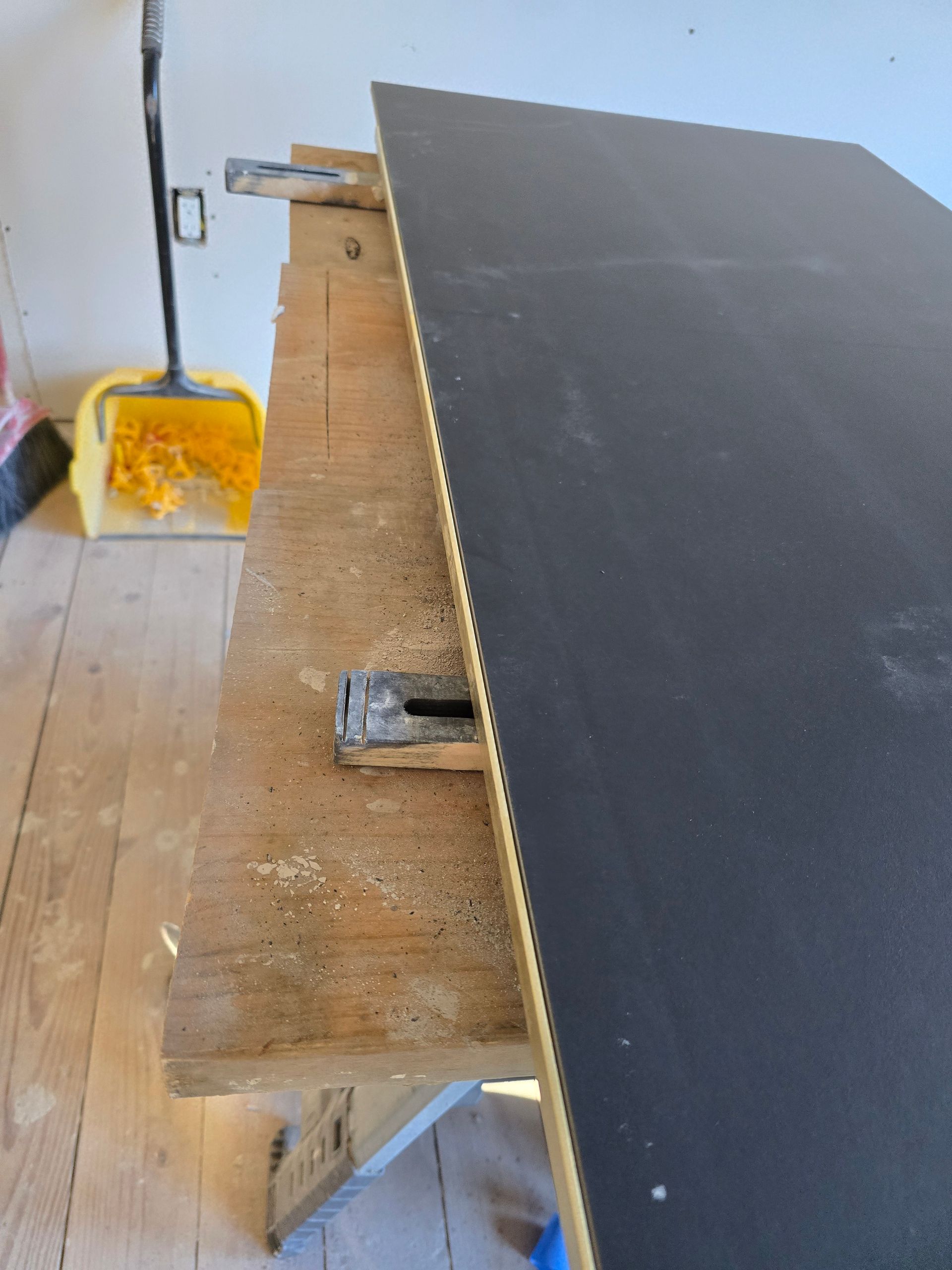 A wooden workbench with a piece of black plywood on it
