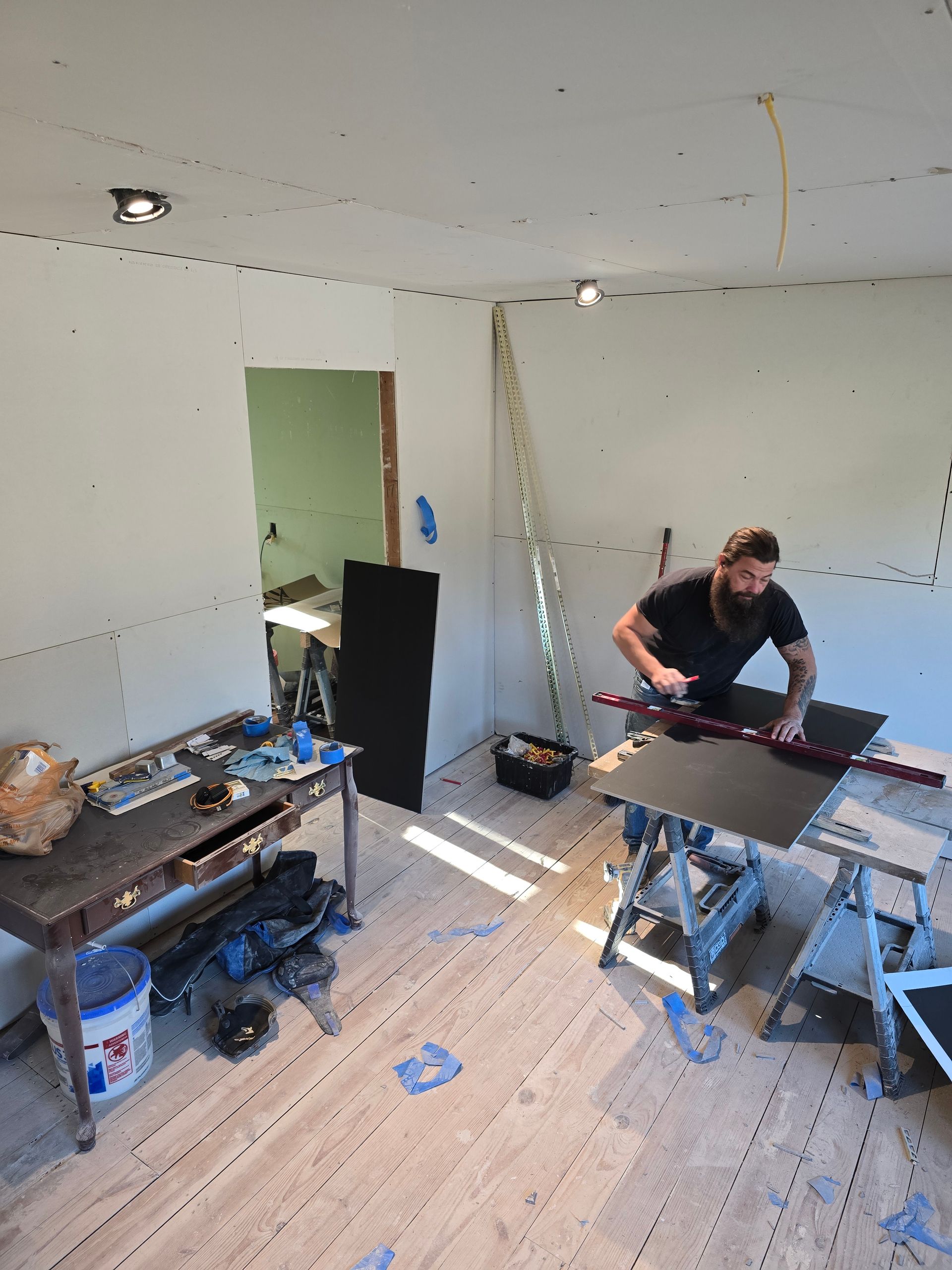 A man is working on a piece of wood in a room.