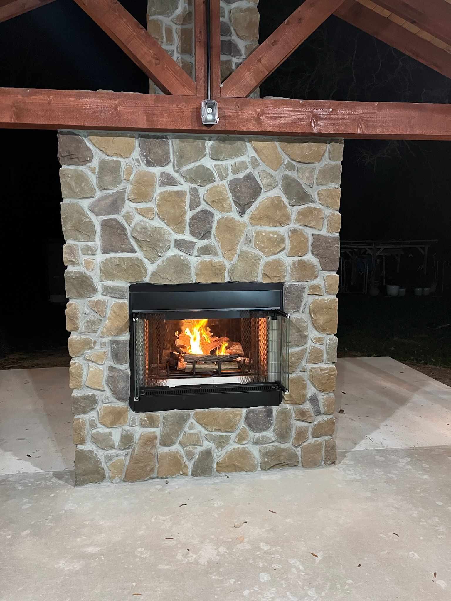 A stone fireplace with a fire coming out of it
