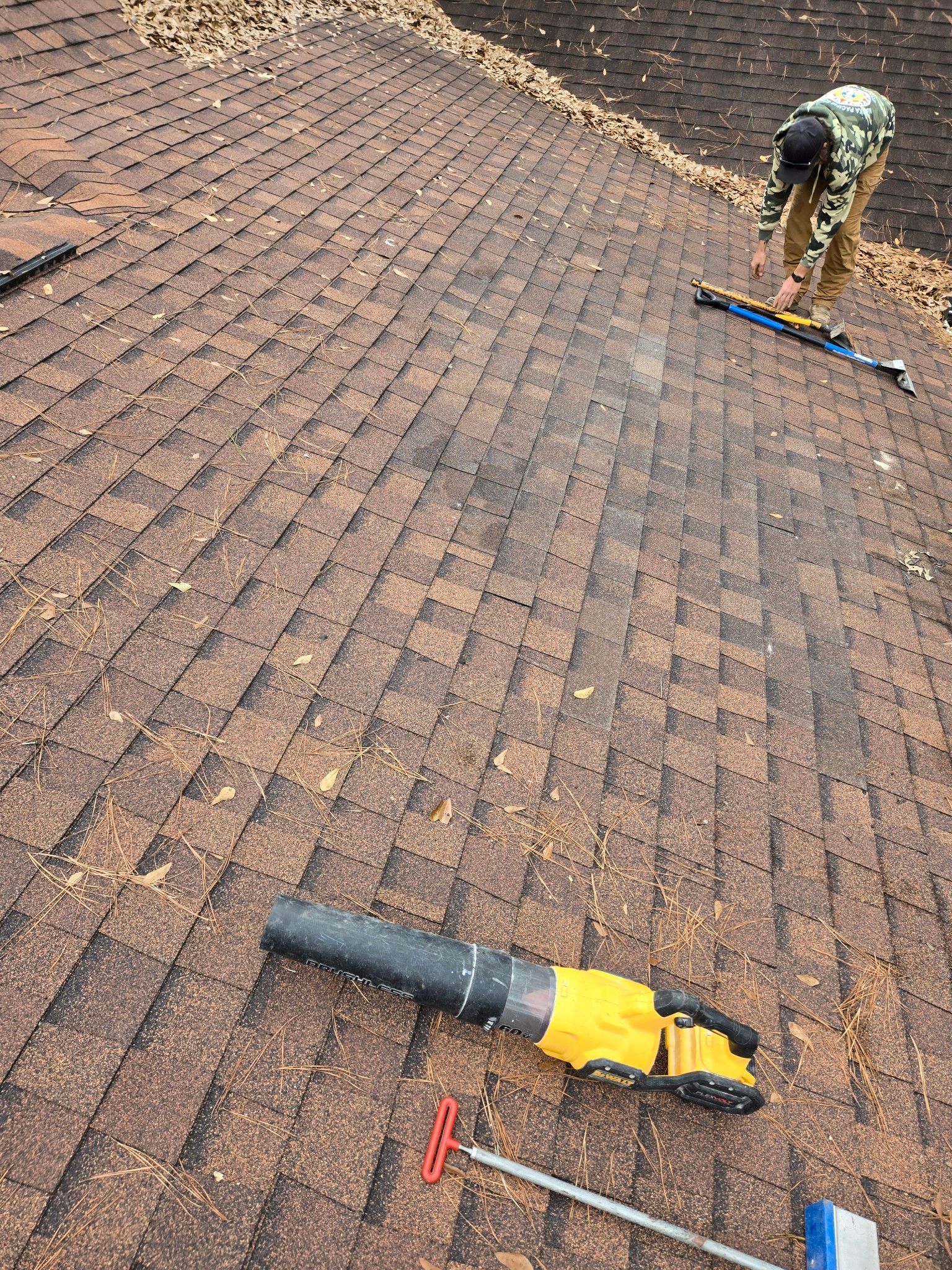 A man is working on a roof with tools on it.