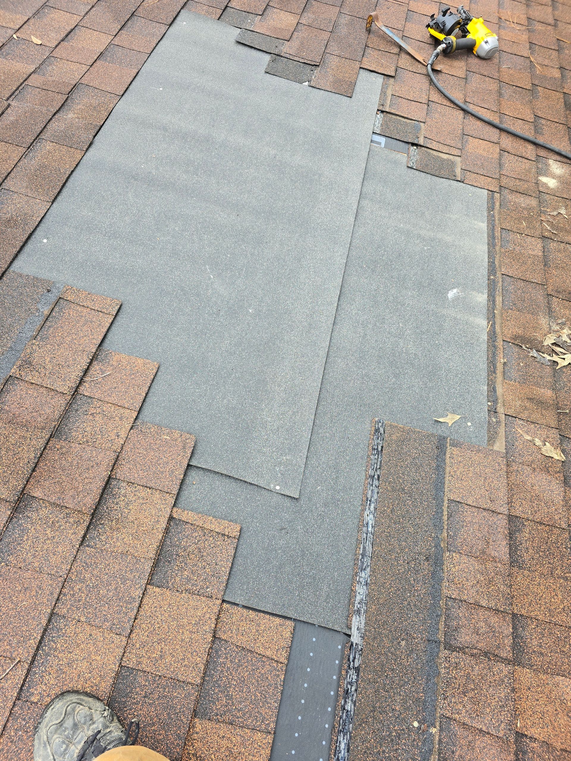A person is working on a roof with a tape measure.
