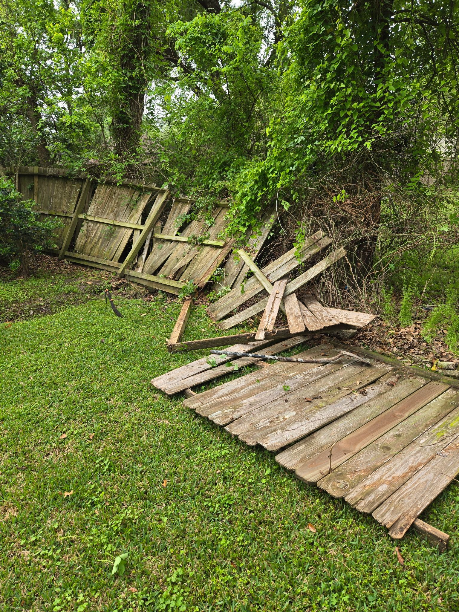 A wooden fence is sitting on top of a lush green field.