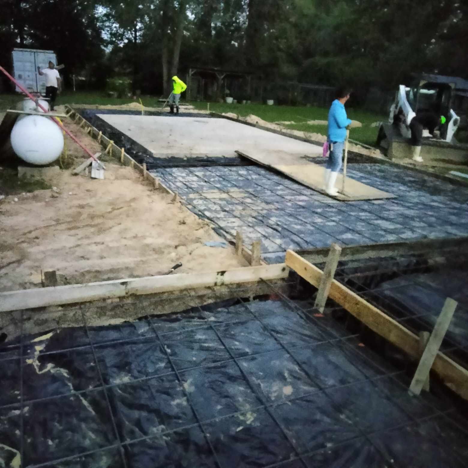 A man in a blue shirt is standing on a concrete floor