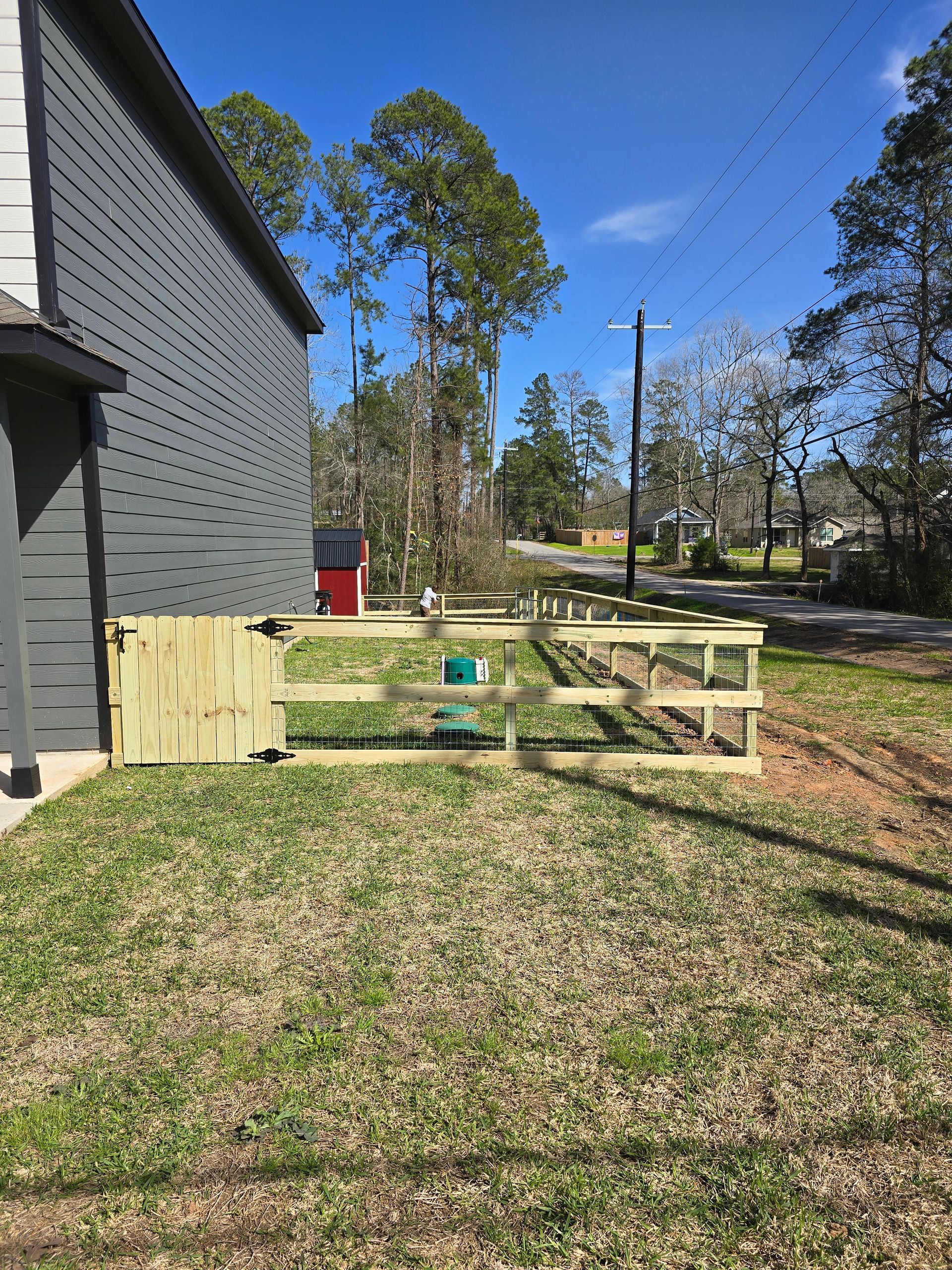 There is a wooden fence in the backyard of a house.