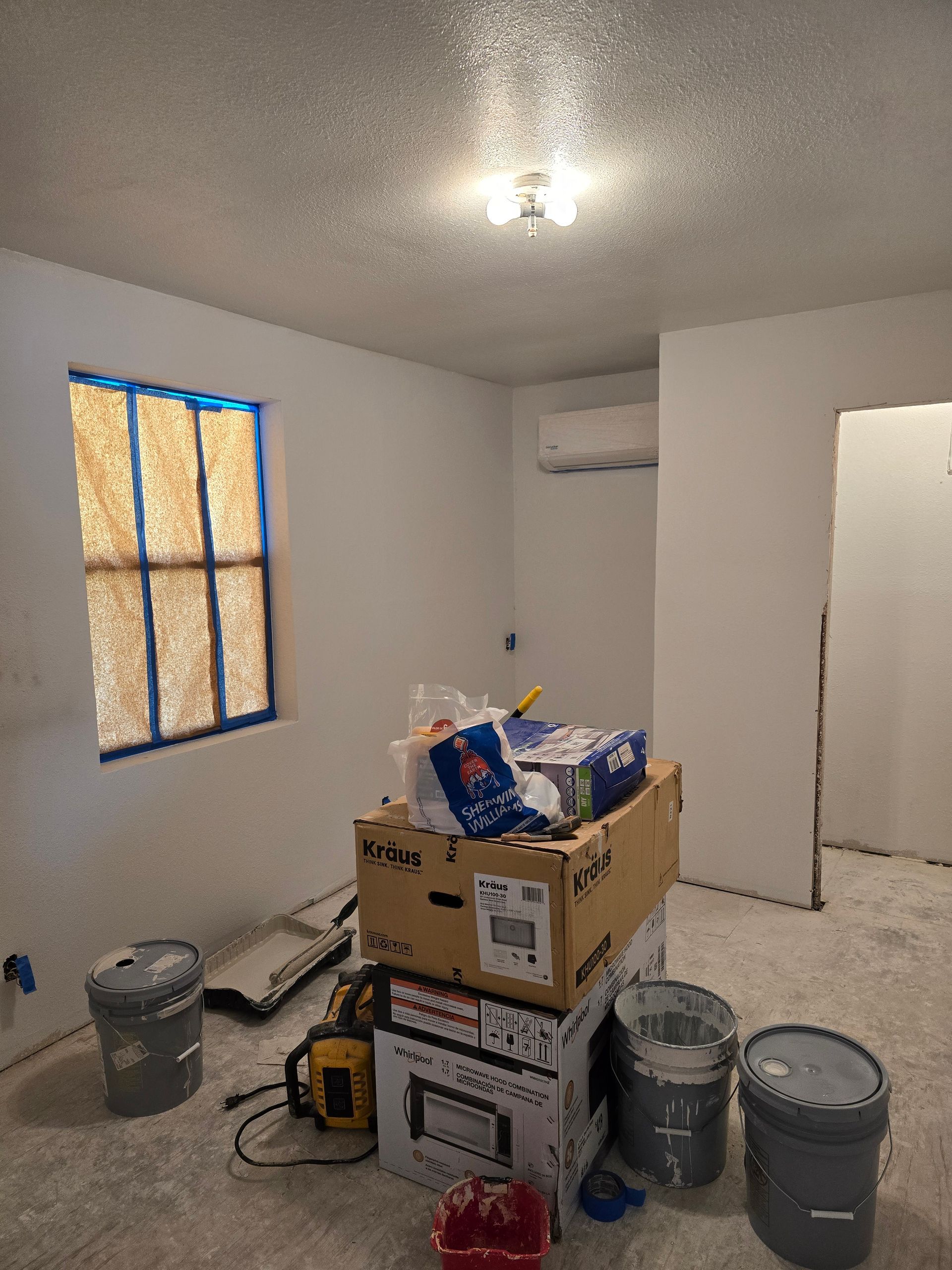 A room with a lot of boxes on the floor and a window.
