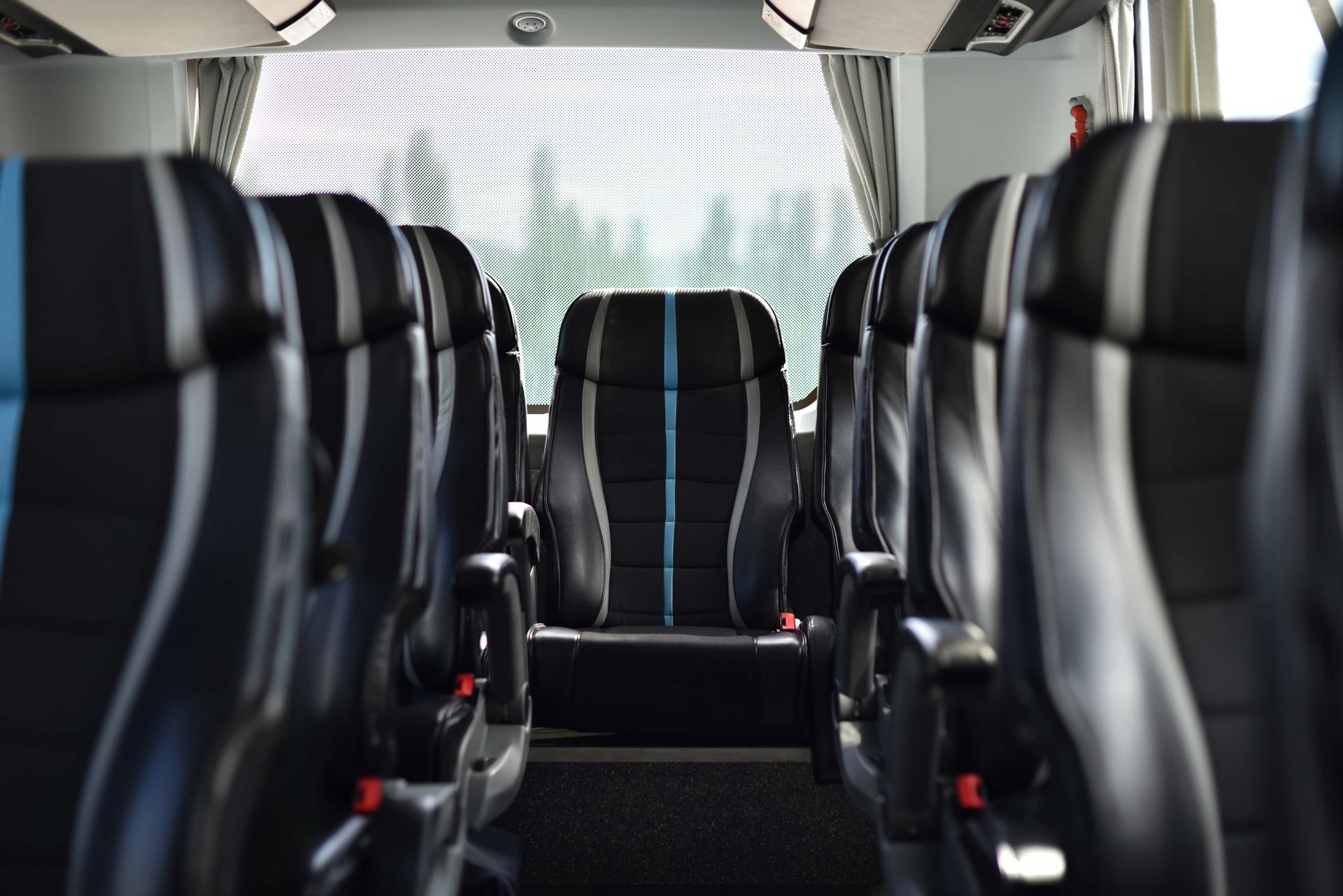 The inside of a bus with black and blue seats.