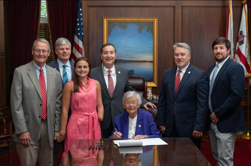 LuLu Gibbins with Governor Ivey during the signing of LuLu's Law